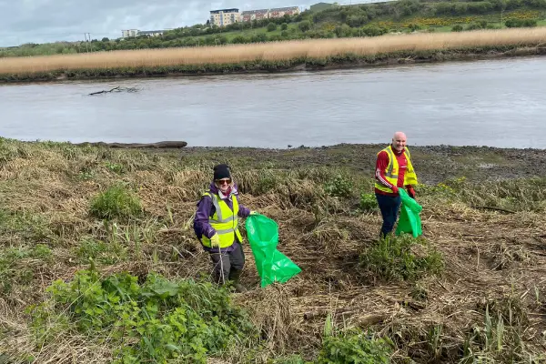 2 old volunteers cleaning up an area